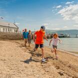 Family on beach at Beaumaris with pier in background.