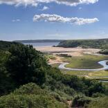 cliffs and field leading to sandy beach.