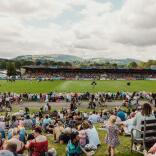 outdoor showground and people watching.